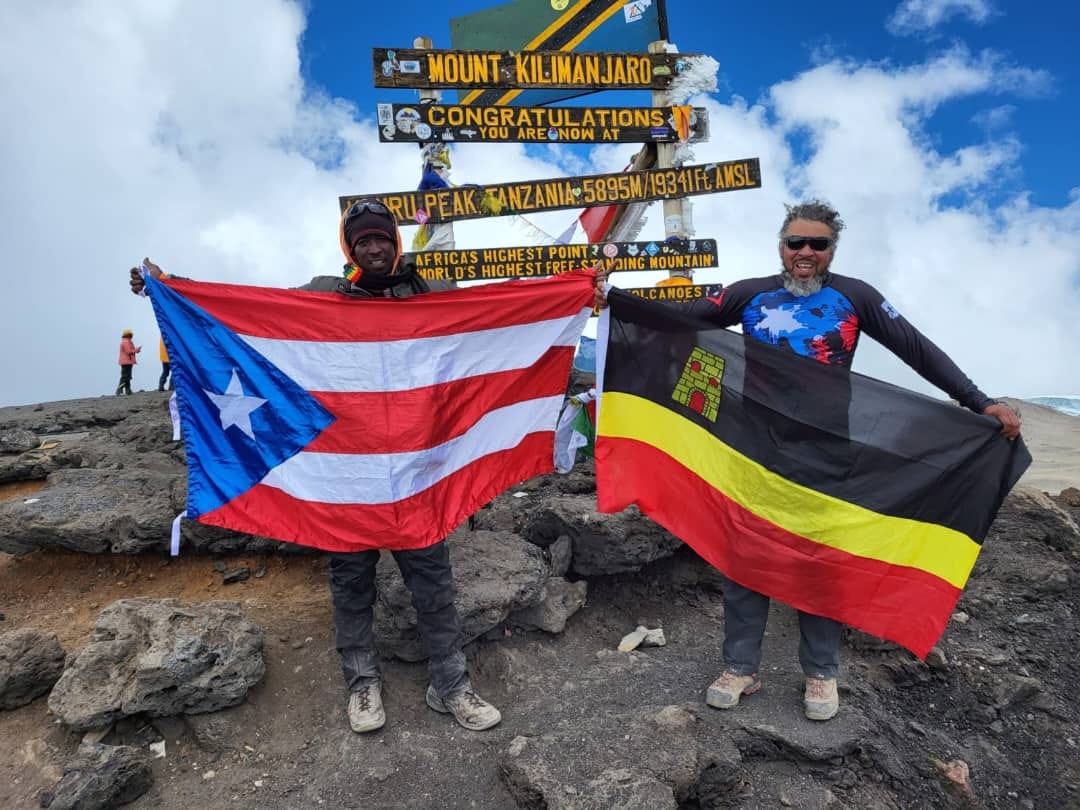 Climbers at the Uhuru Peak sign